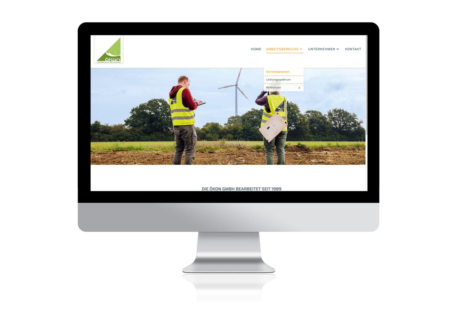 öKon Website: Arbeitsbereiche / Kernkometenzen. MitarbeiterInnen arbeiten vor Windrad. Eine beobachtet mit Fernglas das Windrad, während ihr Kollege Notizen macht.